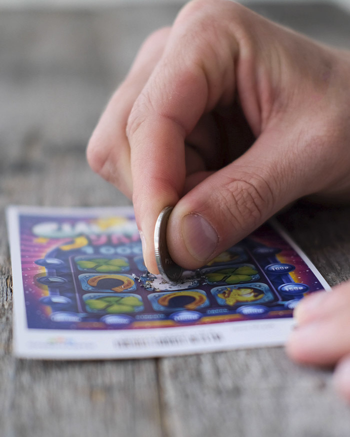 Persona raspando billete de lotería